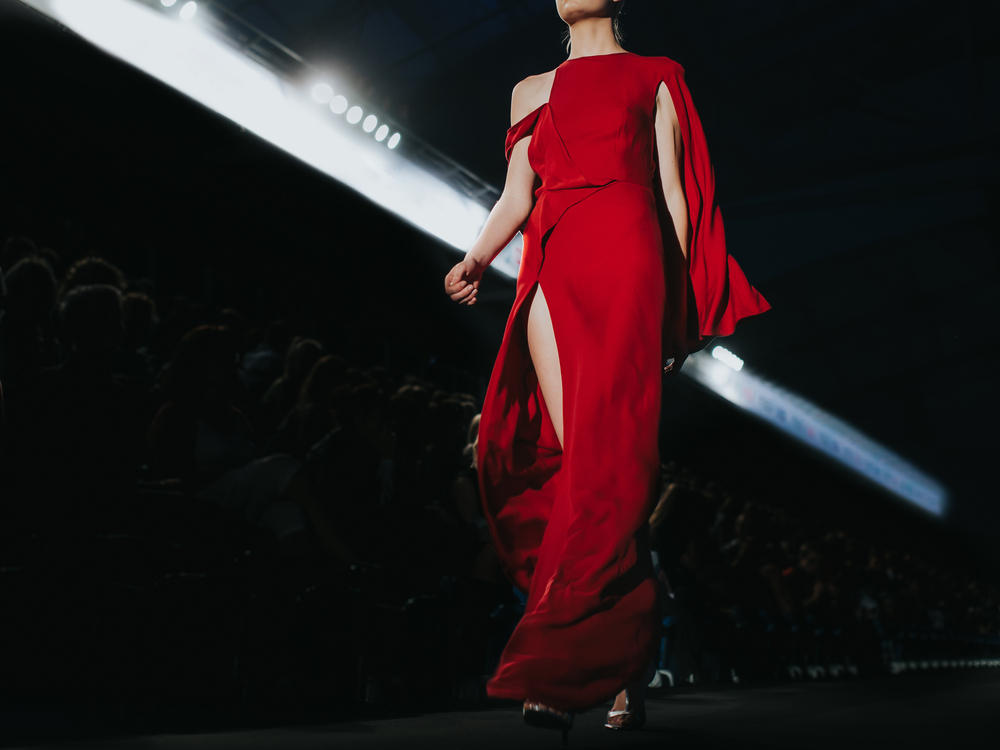 mulher vestida de vermelho desfilando em passarela
